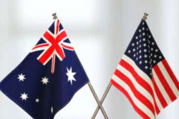 Two crossed national flags on wooden table